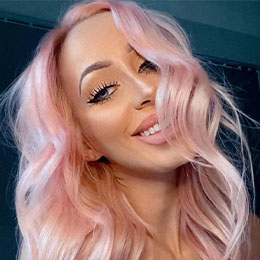 Soft pastel pink hair colour styled in loose waves